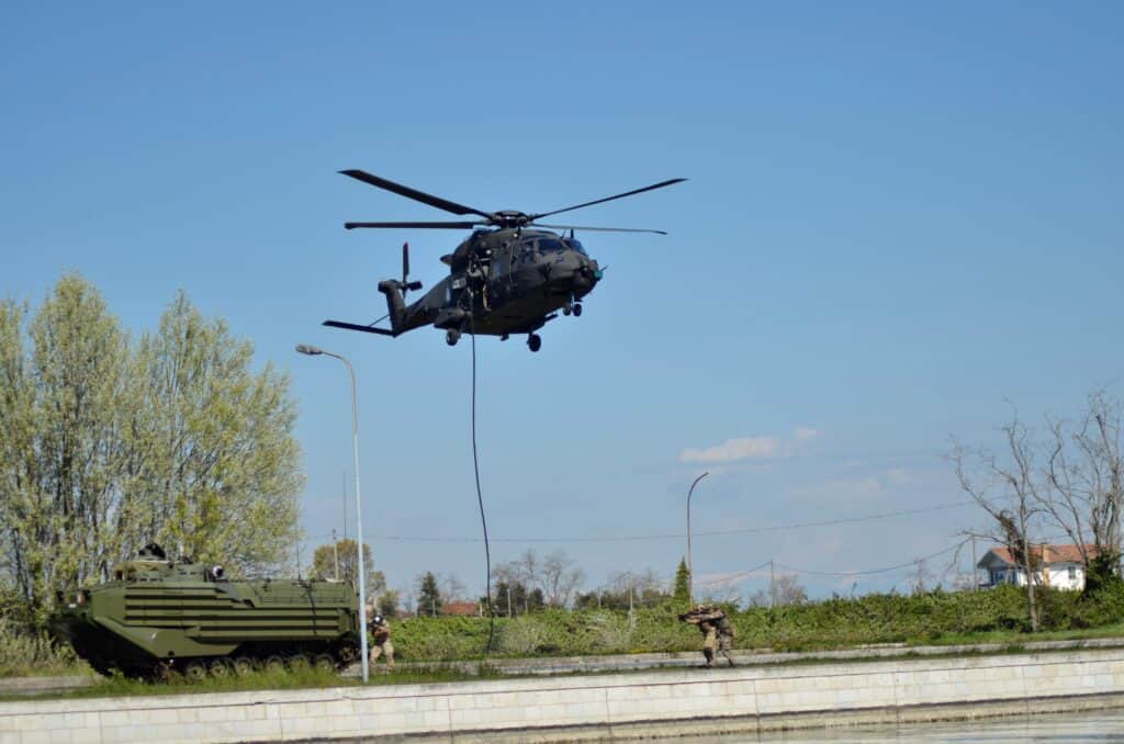Carro anfibio con elicottero NH90 in hovering a premessa del rilascio operatori